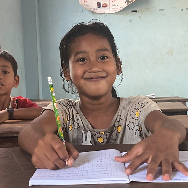 A student smiling at her desk at Savong Education