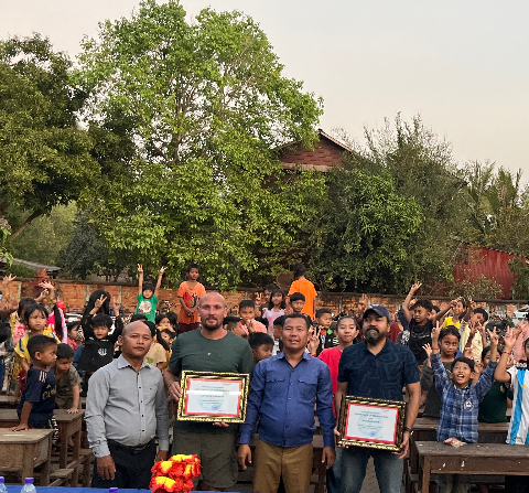 Volunteers receiving certificates alongside students and community at Savong Education